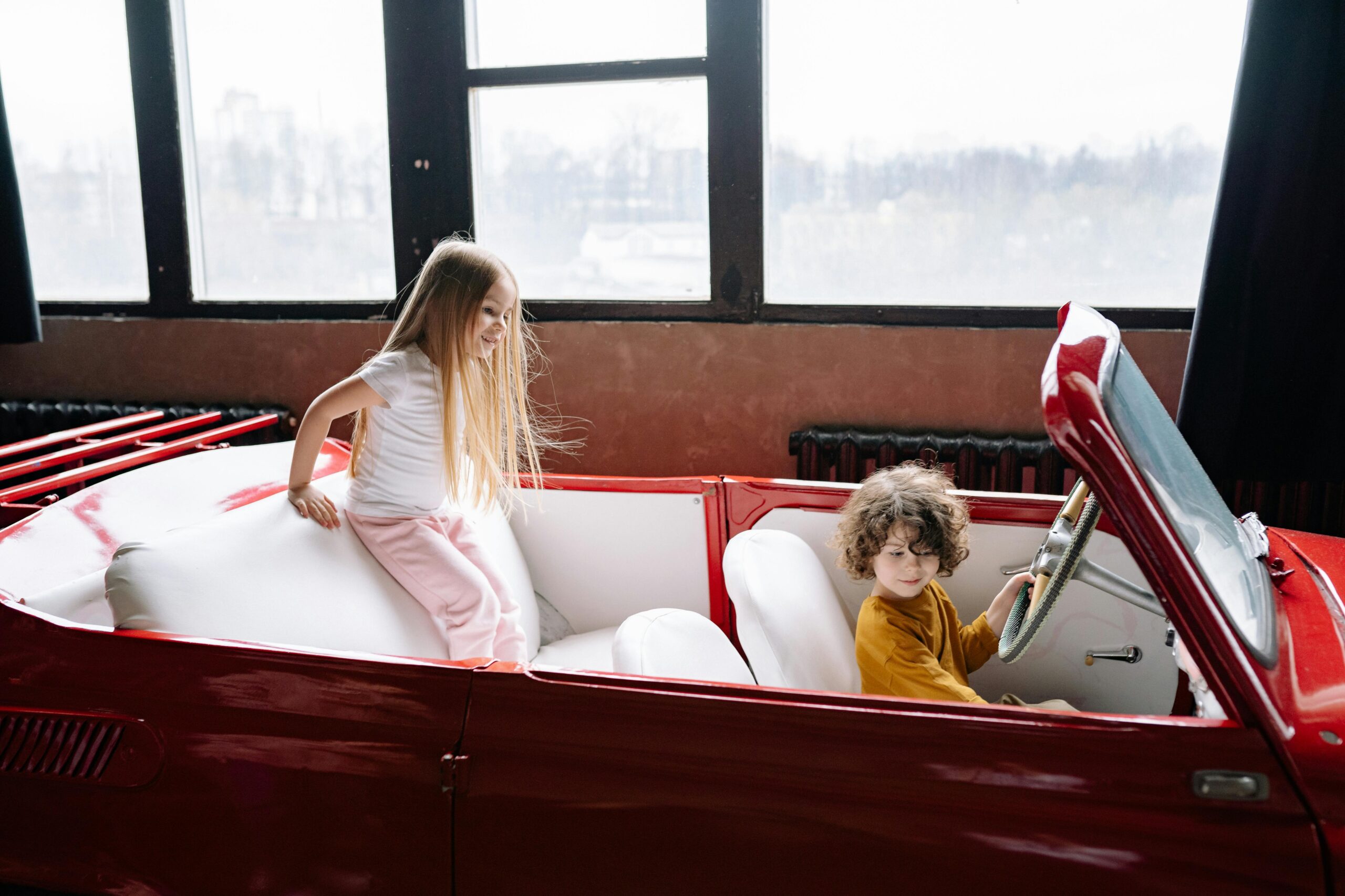 two kids in a classic car